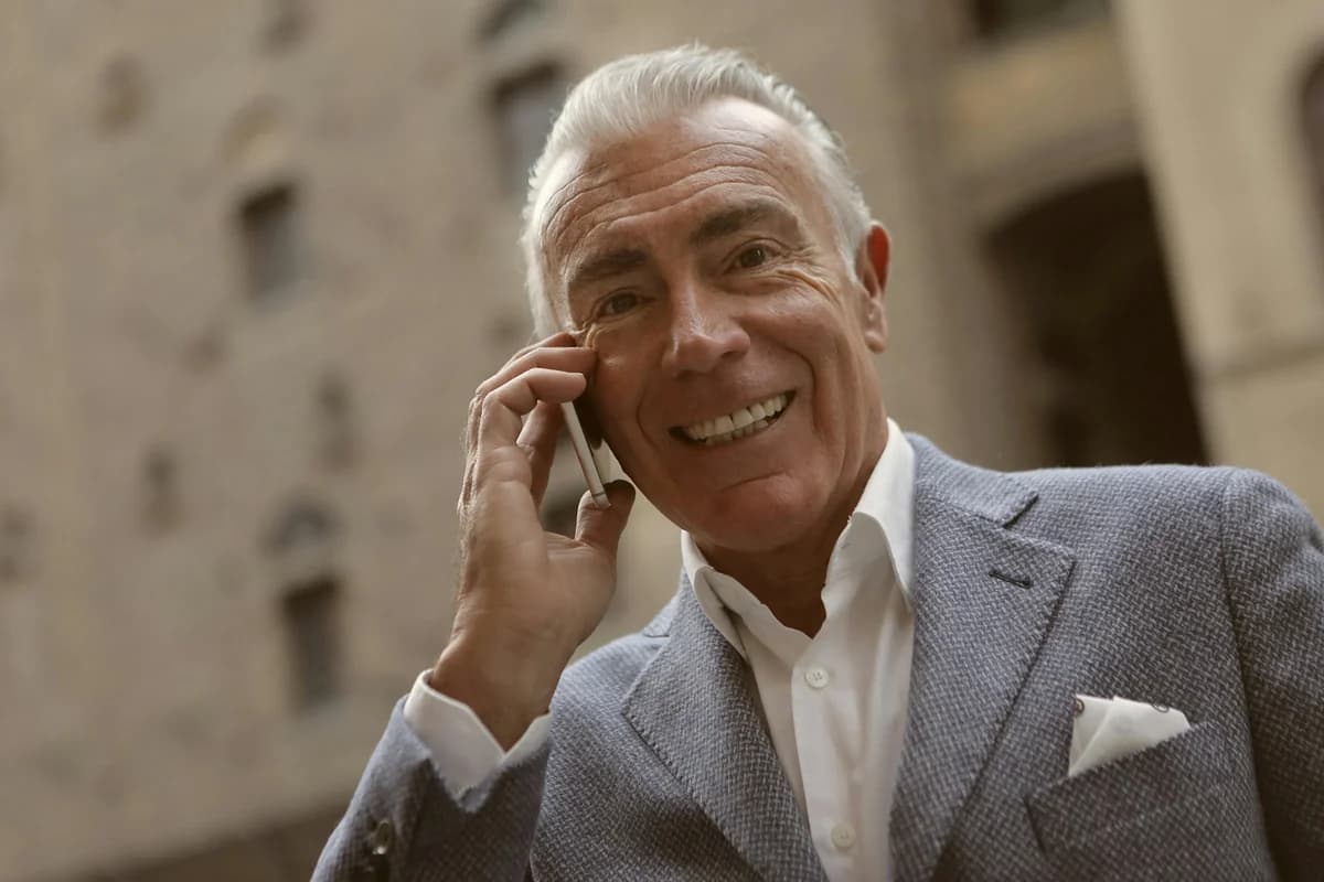 Happy elderly man smiling while talking on the phone